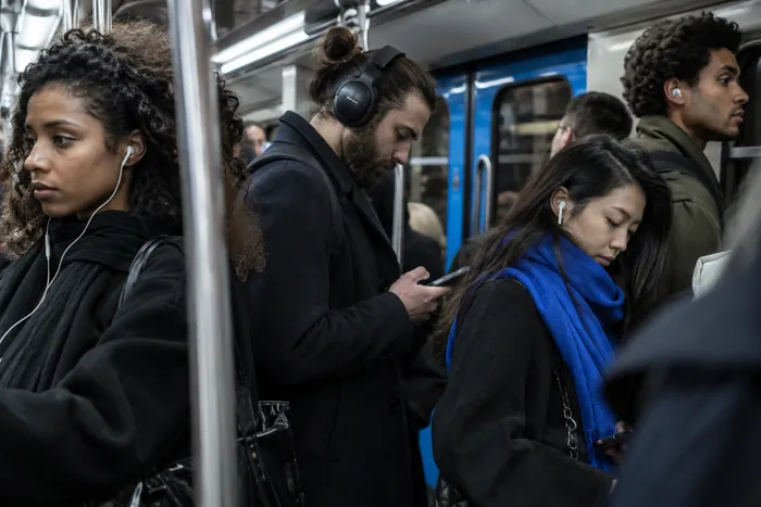 Passagers du métro, écouteurs et téléphones